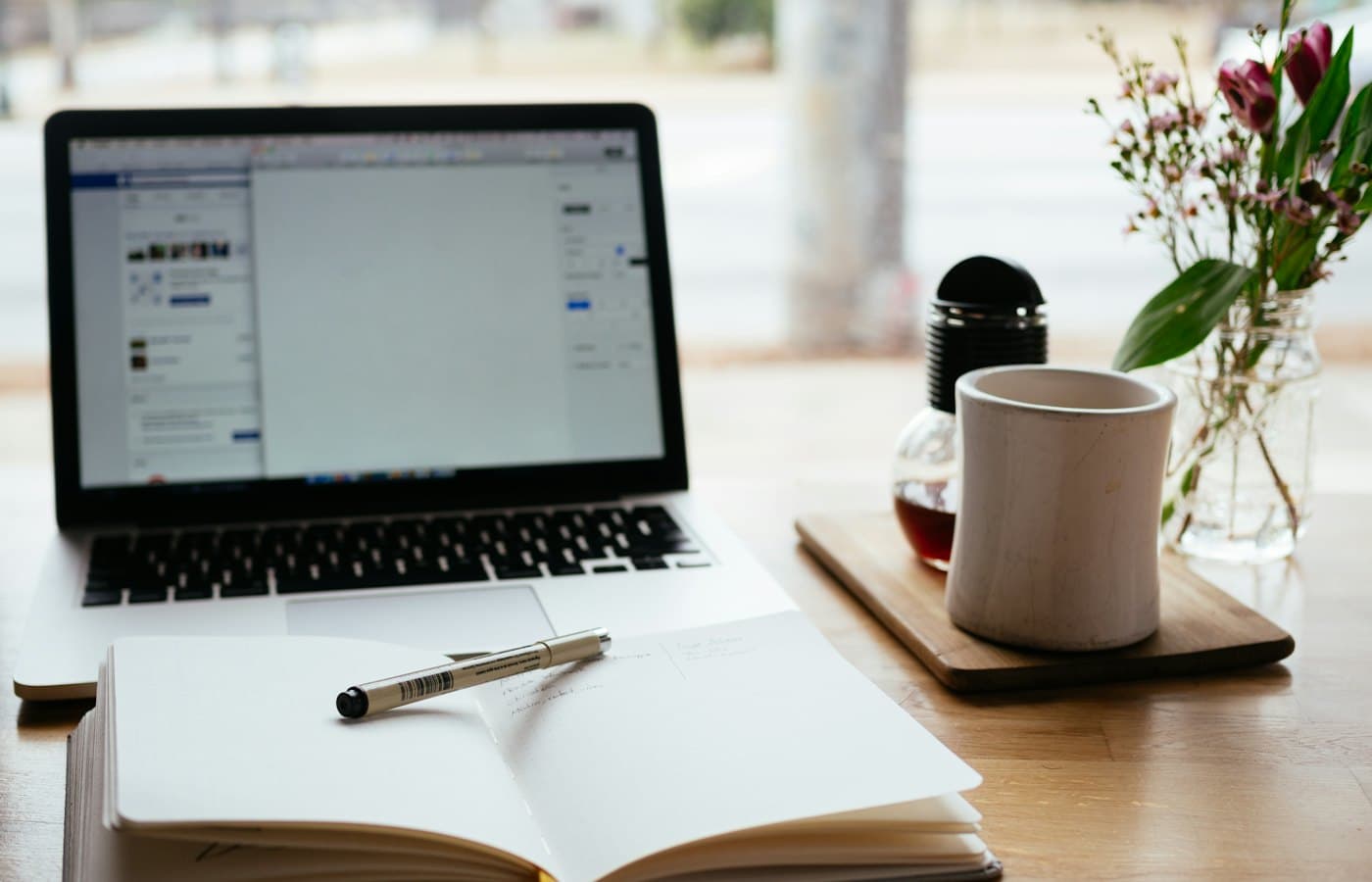 Open notebook beside a laptop on a writer's desk