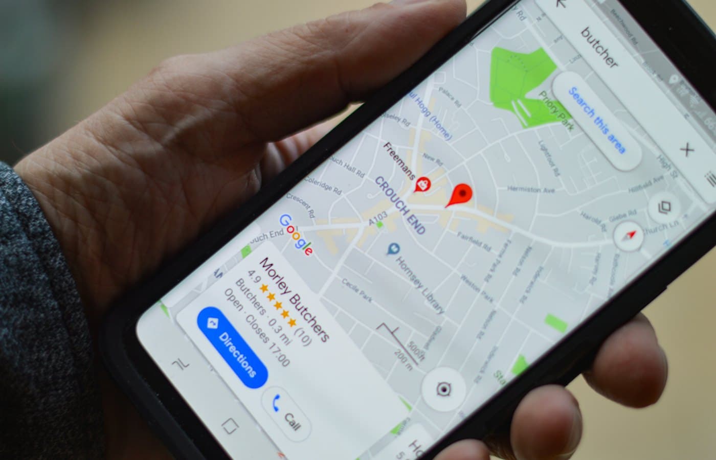 Person holding a smartphone while searching for a local business