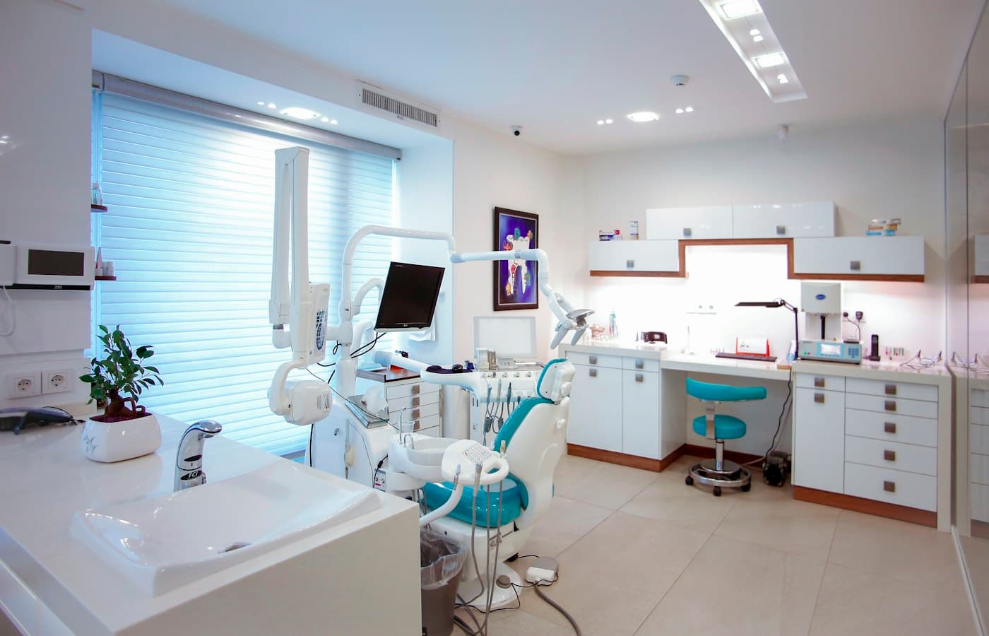 Bright, modern dental treatment room with patient chair and equipment