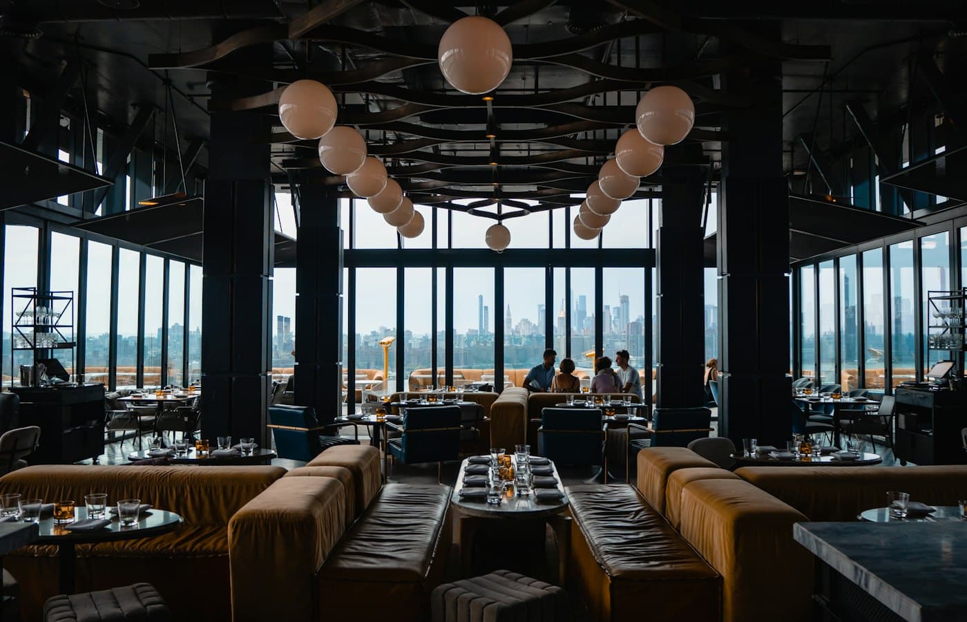 Busy, warmly lit restaurant dining room with guests at their tables